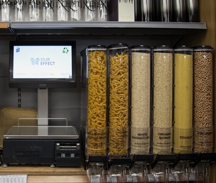 Photograph of self serve machine filled with grains and weighing scales next to it