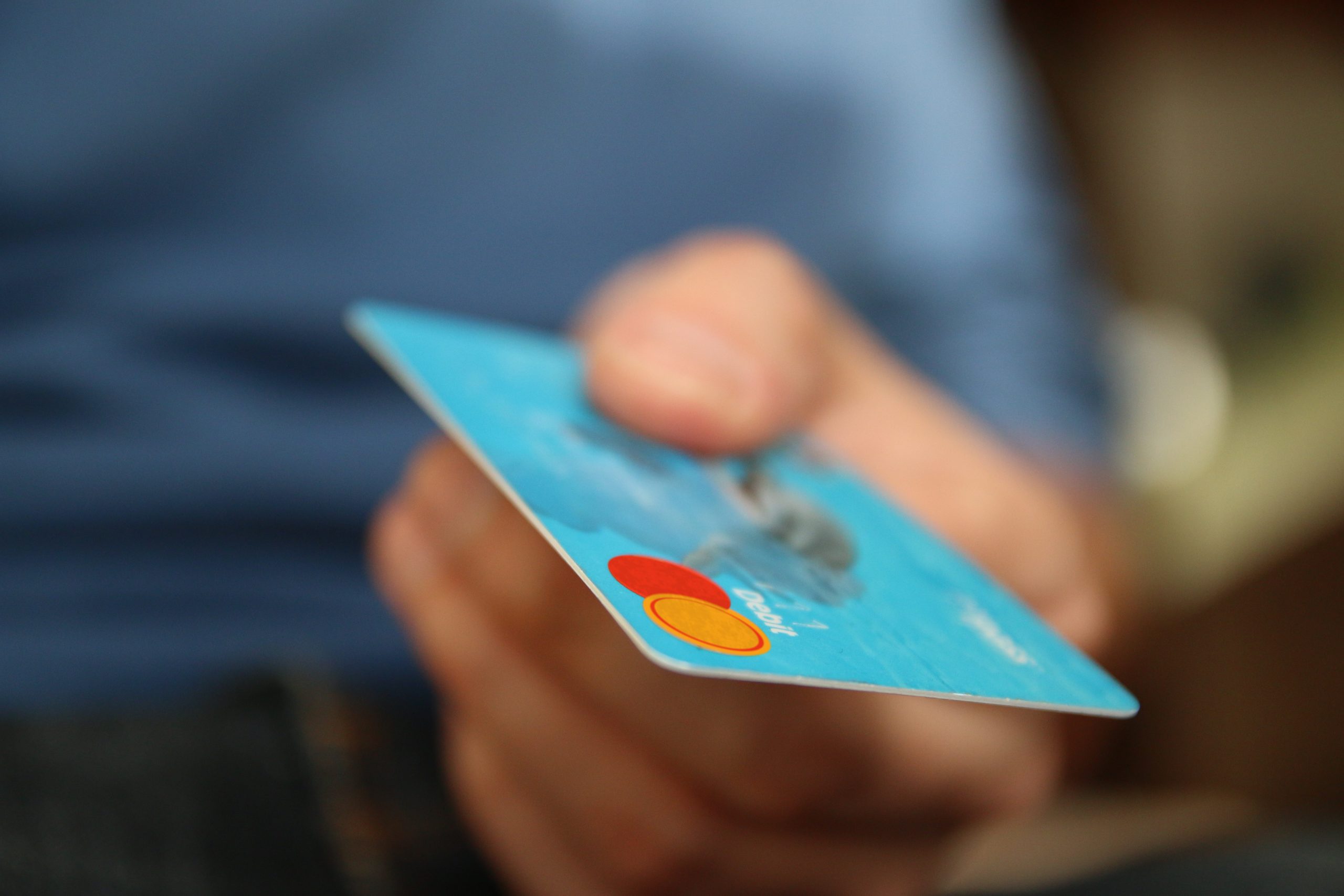 Blurred image of a hand offering a credit card