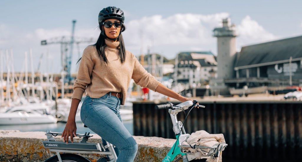 Person sitting on a Beryl e-bike with the National Maritime Museum Cornwall and Falmouth Docks in the background