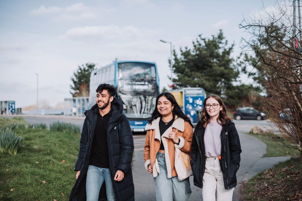 The bus stop at Penryn campus with students walking from the bus.