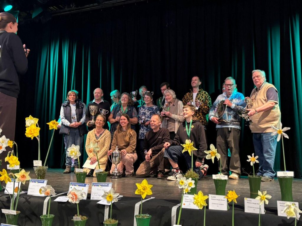 Toby Nenning, Grounds and Gardens Manager at FX Plus with the Shrub Trophy on stage with the other prize winners at the Falmouth Spring Flower Show 2026