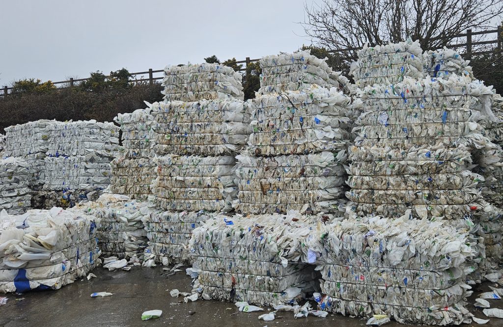Blocks of compacted plastic recycling towered up.