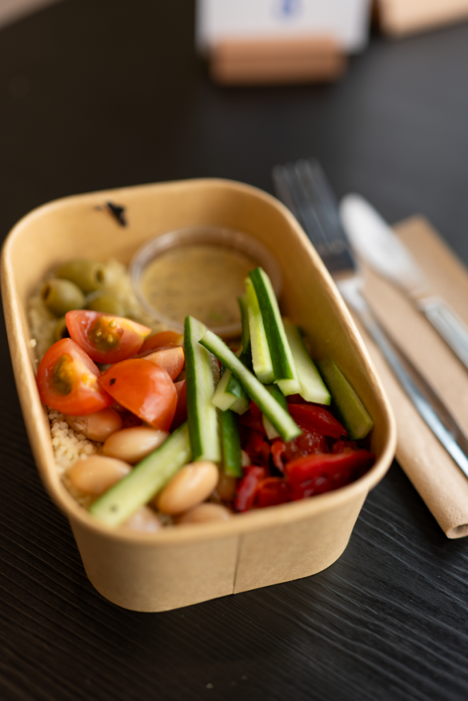 The Sustainability cafe salad, featuring cous cous, tomato, beans, cucumber, olives and salad dressing. All served in a recyclable container